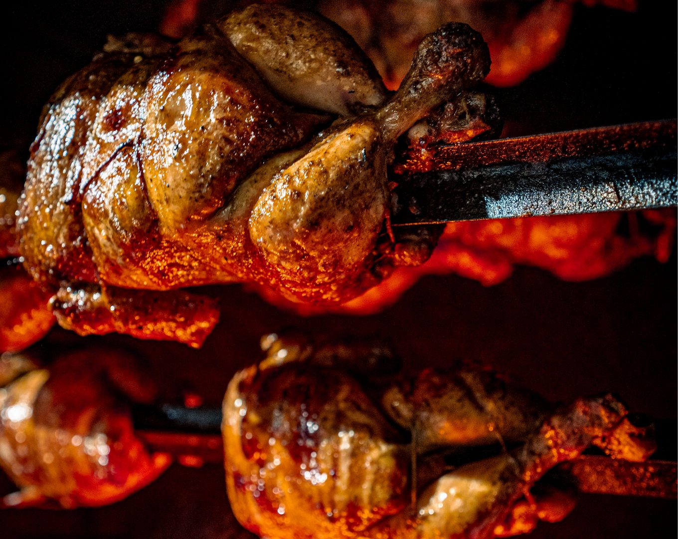 Whole chicken grilling over open fire