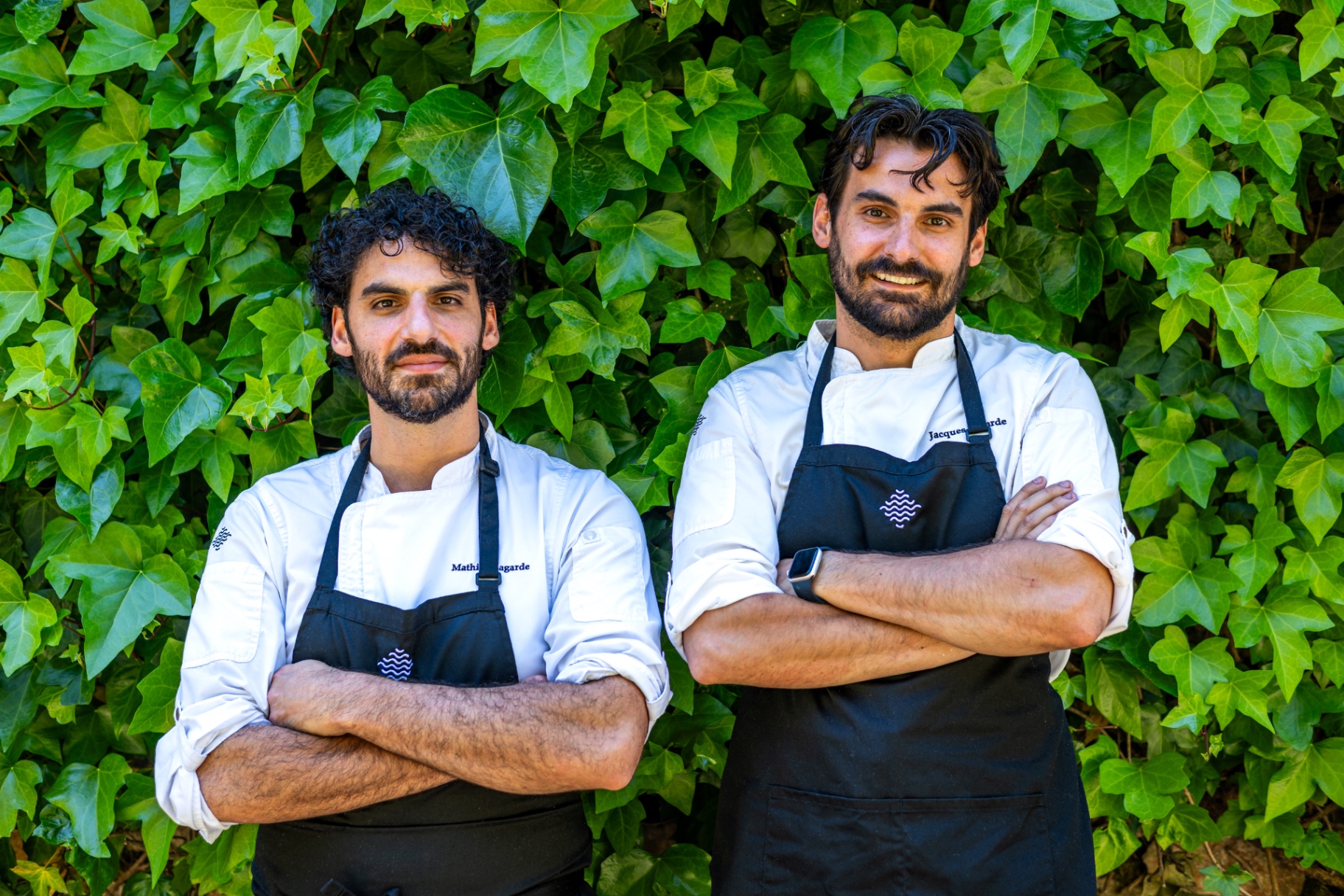 Jacques and Mathieu Lagarde, chefs at Cascada Marbella, standing together against an ivy wall
